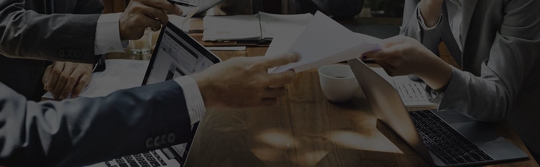 Professionals in suits exchanging documents