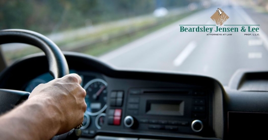 closeup view of a truck dashboard with a pair of hands on the wheel